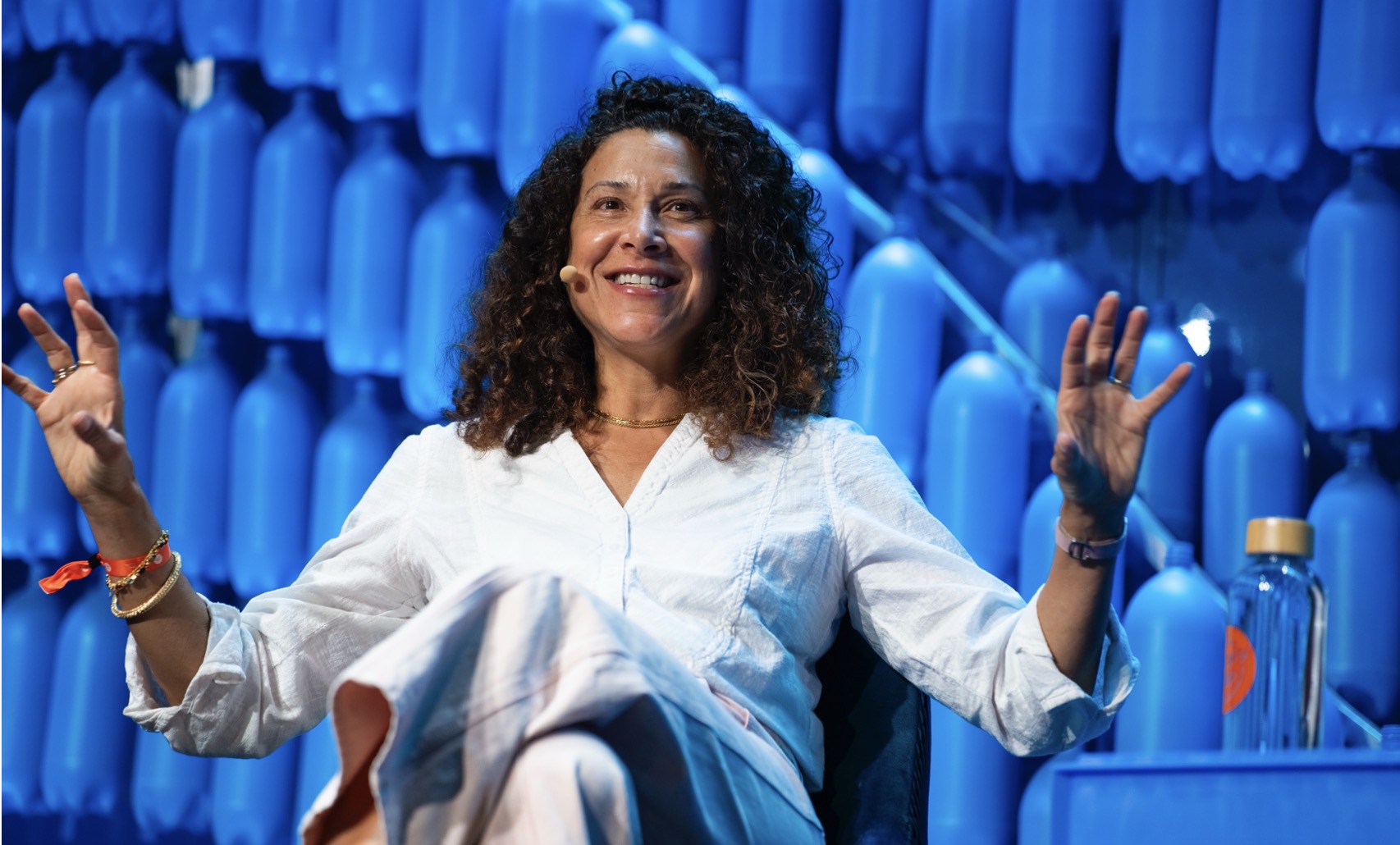 A person with curly hair and microphone AI-generated content may be incorrect.